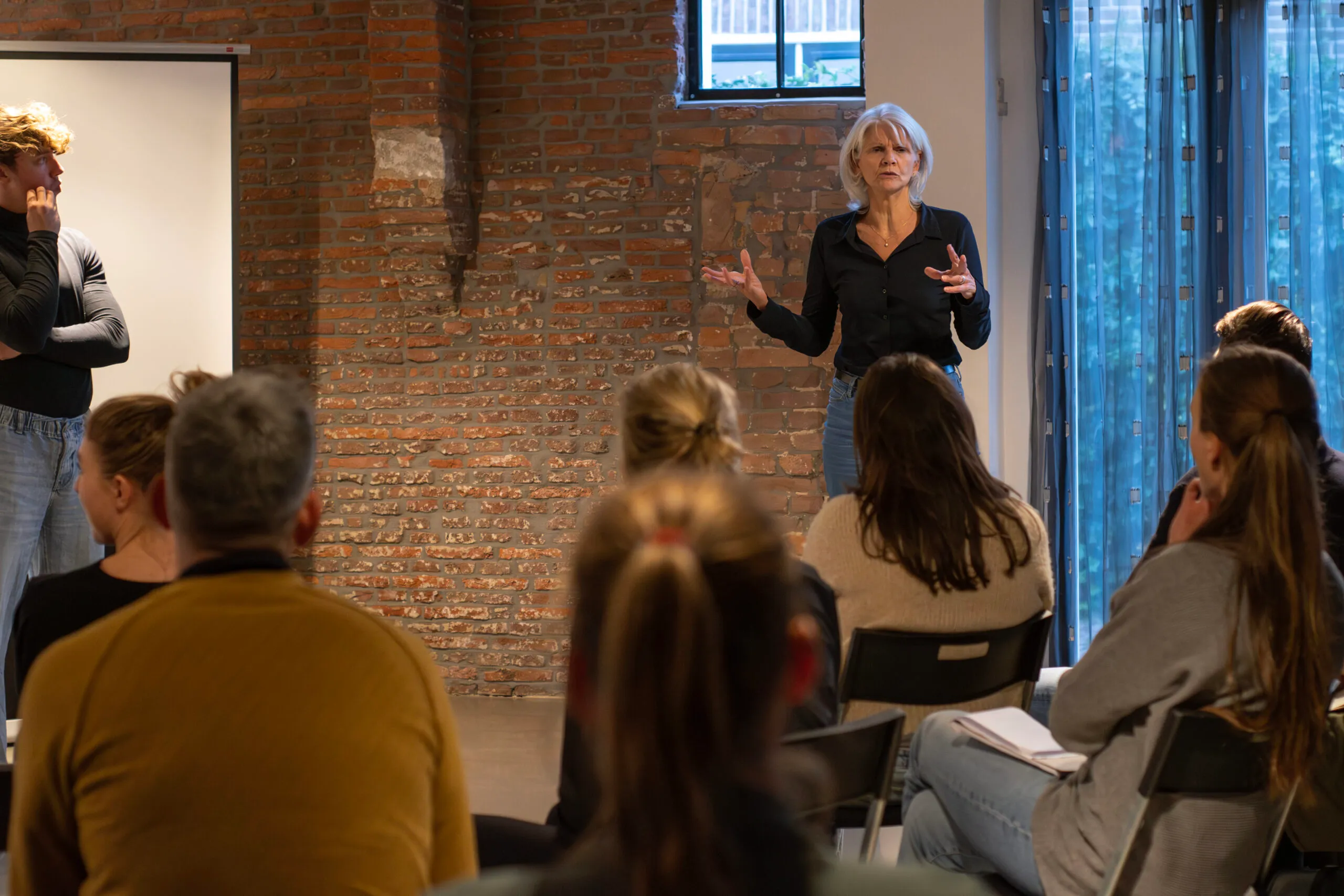 Deelnemers in gesprek met een spreker tijdens de studiedag
